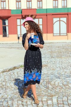 pretty woman in retro dress and hat drinking hot drink or  bever