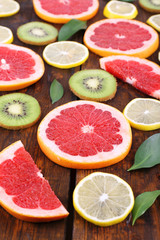 Ripe slices lemon, kiwi and grapefruit on wooden background