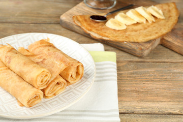 Plate of delicious pancakes on wooden background