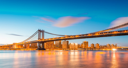 Fototapeta na wymiar Amazing sunset view of Manhattan Bridge with East River reflecti