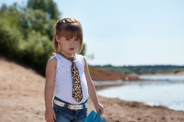 Serious little model posing on lake background