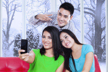 Three friends taking picture with cellphone