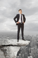 Businessman standing on a peak