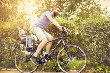 Obraz premium Father and daughter on bicycle in park
