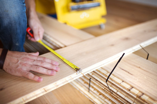 Handyman measuring wooden floor