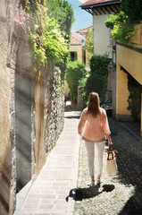 Girl on the cobbled street of Menaggio town. Lake Como, Italy