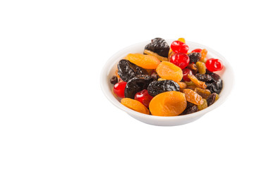 Mix variety of dried fruit in white bowl over white background