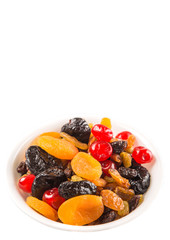 Mix variety of dried fruit in white bowl over white background
