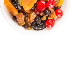 Mix variety of dried fruit in white bowl over white background