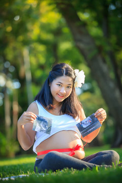 Beautiful pregnant asian woman show image of the baby