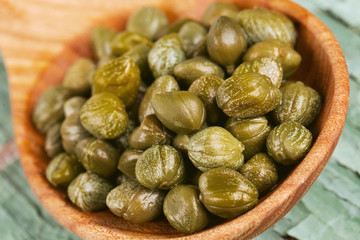 capers in a wooden spoon
