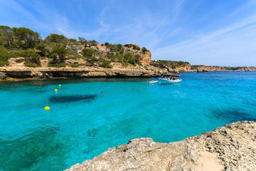 Boat in bay on azure sea water, Cala Llombards, Majorca island