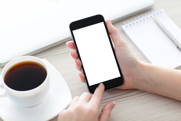 Women hands holding the phone with isolated screen above desk