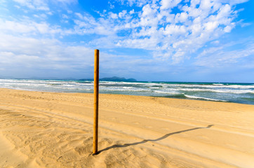 Wooden pole on sandy Can Picafort beach, Majorca island, Spain