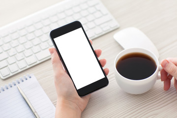 Women hands holding the phone and cup of coffee