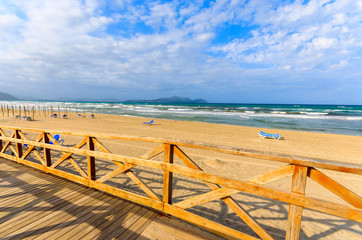 Fototapeta premium Wooden fence on Can Picafort beach and clouds, Majorca island