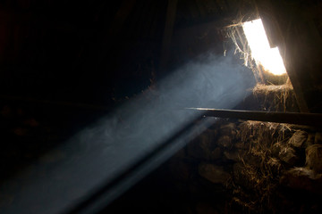A bright sunbeam enters an old hay barn