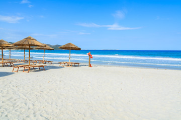 Fototapeta na wymiar Villasimius beach with sunchairs and umbrellas, Sardinia island