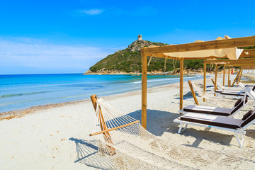 Hammocks on white sand beach in Porto Giunco bay, Sardinia