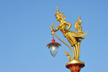 Fototapeta na wymiar Golden Kinnaree lamp on blue sky