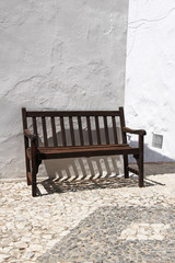 vintage wooden bench against whitewashed wall © chrupka
