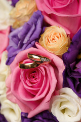 Gold wedding rings on a bouquet of flowers for the bride