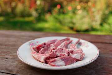 Raw rack of lamb on vintage plate