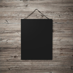 black blank poster hanging on leather belt on wood background