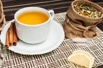 cup of tea with lemon over wooden background