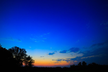 Illuminated by the sun clouds at sunset on a background of blue sky