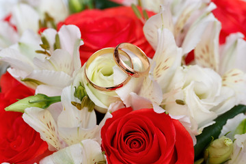 Gold wedding rings on a bouquet of flowers for the bride