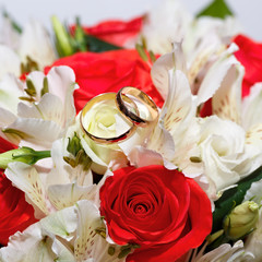Gold wedding rings on a bouquet of flowers for the bride