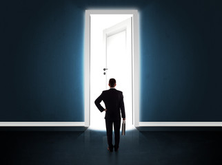 Fototapeta premium Business man looking at big bright opened door