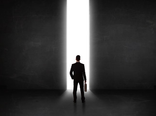 Business person looking at wall with light tunnel opening