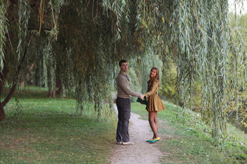 Obraz premium loving couple in autumn park sunbeams sunset