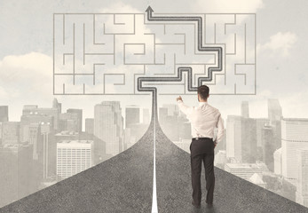 Businessman looking at road with maze and solution