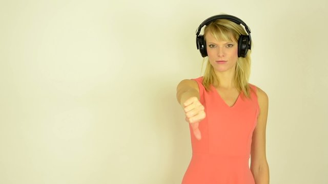 woman listens music headphones-showing thumbs on disagreement
