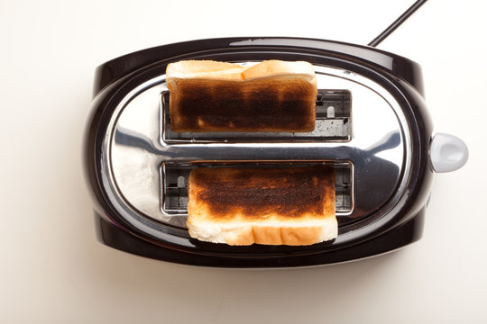 Black toaster, two burnt black slices of bread