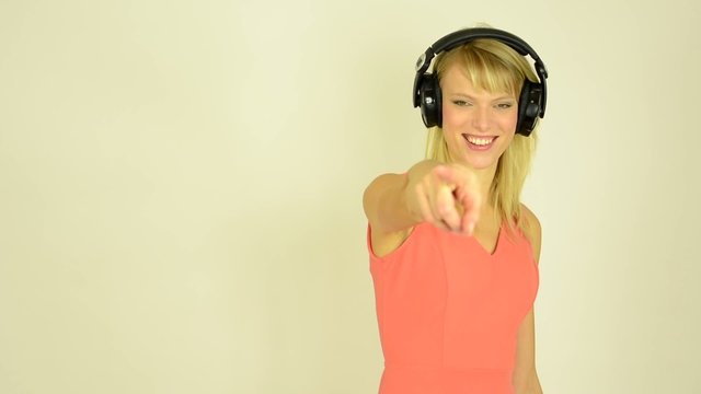 woman listens to music with headphones and woman pointing