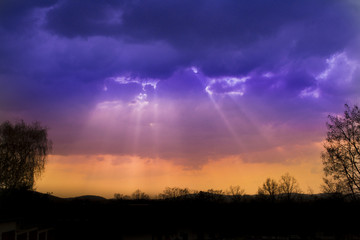 Fototapeta na wymiar Sun rays through clouds before storm
