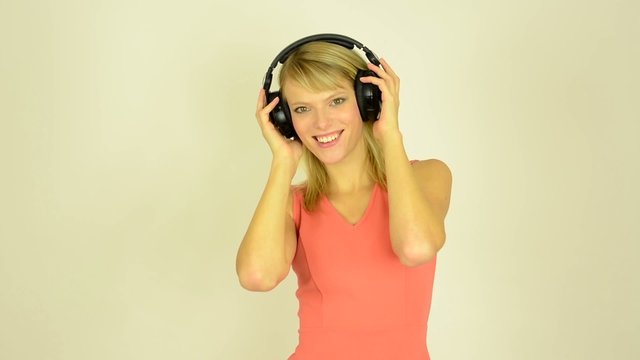 woman listens to music with headphones and dancing - studio