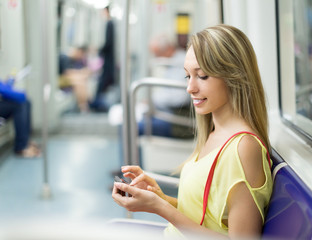 Obraz na płótnie Canvas Girl with smartphone in metro