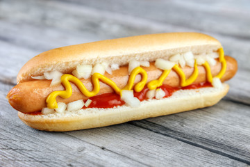 Hot dog with ketchup , yellow mustard and onion