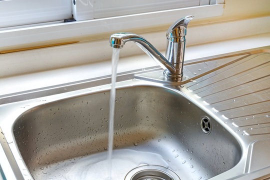 Kitchen faucet with a flowing water