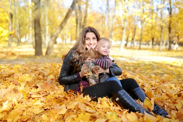 Fototapeta premium mother and the kid walk in autumn park