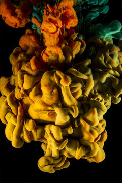 orange, yellow and green ink color drop on black background