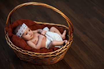 newborn with a crown in  basket on  floor