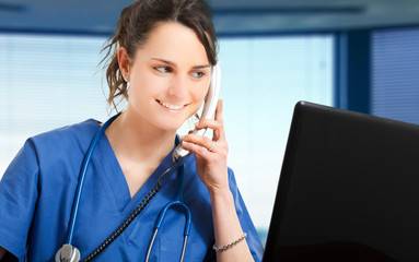 Young female nurse talking at the phone