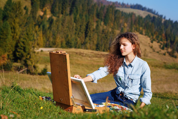 Young painter at work in the mountains