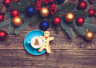 Hot cappuccino with christmas tree shape on a wooden table near